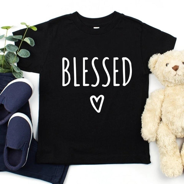 May include parent and child wearing a black Blessed Parent and Mini matching t-shirts.
