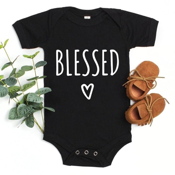 May include parent and child wearing a black Blessed Parent and Mini matching t-shirts.
