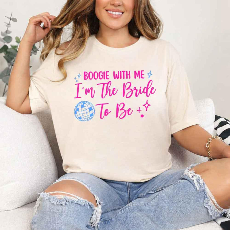 May include a Soft Cream retro-style graphic tee with bold disco lettering reading “Boogie With Me, I’m The Bride To Be,” featuring playful fonts and festive design elements!