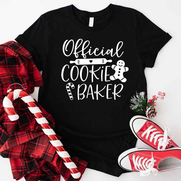 May include a Christmas-themed t-shirt reading “Official Cookie Baker and Tester,” featuring festive colors and cookie graphics, ideal for holiday bakers.