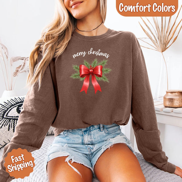 May include a Comfort Colors T-shirt featuring a Christmas bow graphic in coquette aesthetic style with soft vintage tones.