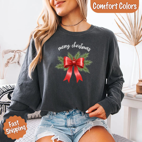 May include a Comfort Colors T-shirt featuring a Christmas bow graphic in coquette aesthetic style with soft vintage tones.