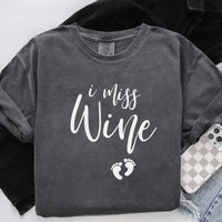 Charcoal gray unisex t-shirt with 'I miss wine' text and small baby footprints graphic.