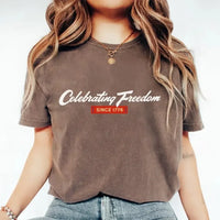 Person wearing a brown t-shirt with 'Celebrating Freedom Since 1776' text.