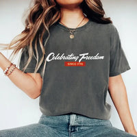 Person wearing a gray t-shirt with 'Celebrating Freedom Since 1776' text.