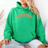 May include a unisex fall hoodie with “Cozy Vibes” text, featuring a soft fleece texture and autumn-inspired colors.
