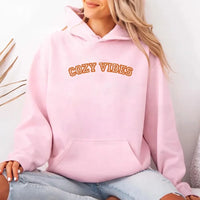 May include a unisex fall hoodie with “Cozy Vibes” text, featuring a soft fleece texture and autumn-inspired colors.