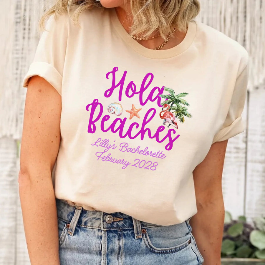 May include Cream bridesmaids wearing custom matching beach bachelorette T-shirts, relaxed seaside setting with sand and ocean backdrop, coordinated outfits, smiling and celebrating together outdoors!