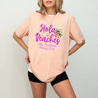 May include Peach bridesmaids wearing custom matching beach bachelorette T-shirts, relaxed seaside setting with sand and ocean backdrop, coordinated outfits, smiling and celebrating together outdoors!