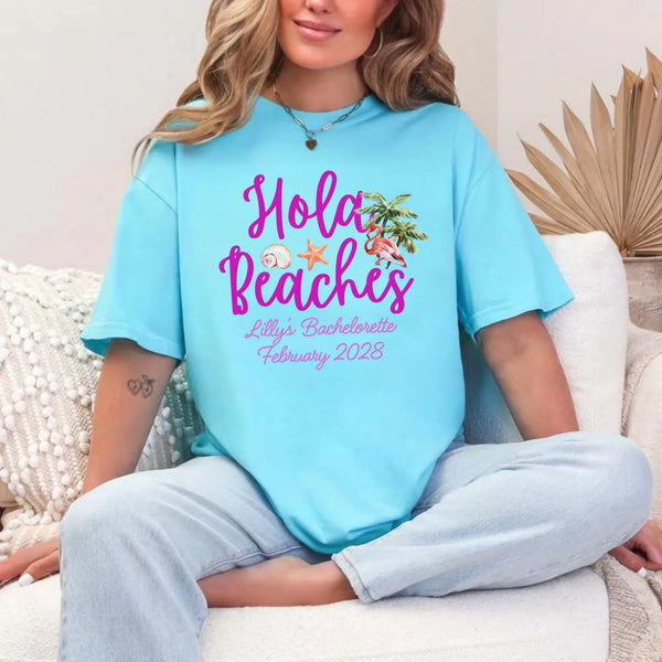 May include Turquoise bridesmaids wearing custom matching beach bachelorette T-shirts, relaxed seaside setting with sand and ocean backdrop, coordinated outfits, smiling and celebrating together outdoors!