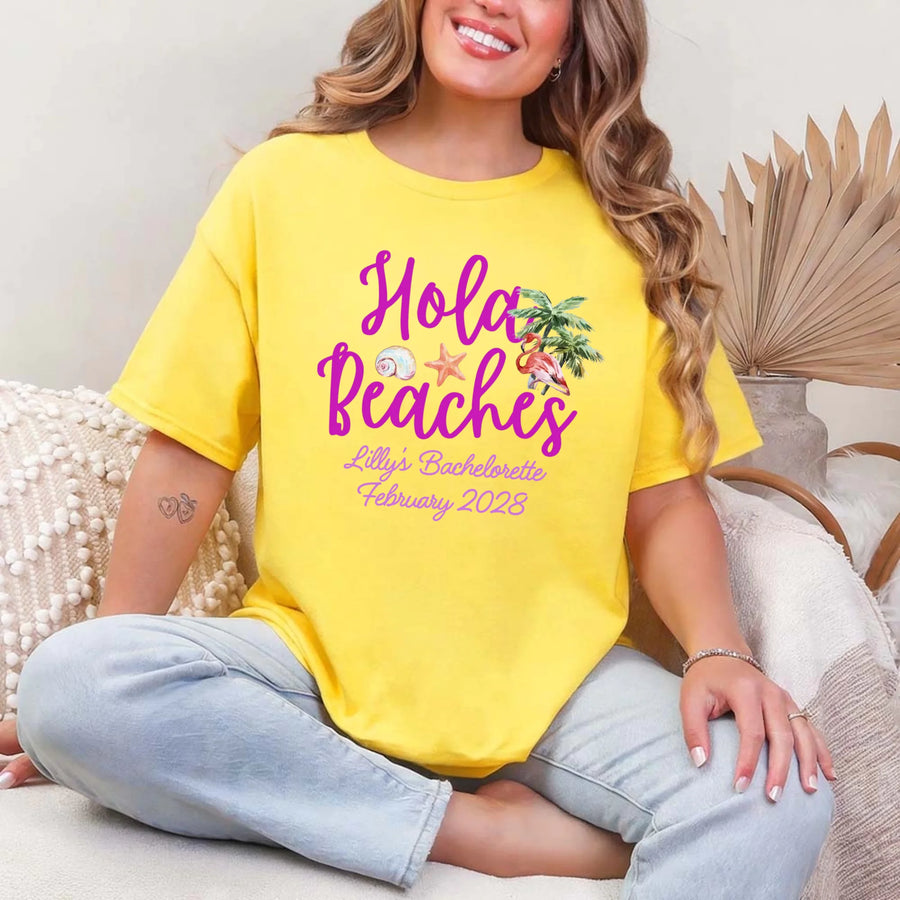 May include Daisy bridesmaids wearing custom matching beach bachelorette T-shirts, relaxed seaside setting with sand and ocean backdrop, coordinated outfits, smiling and celebrating together outdoors!