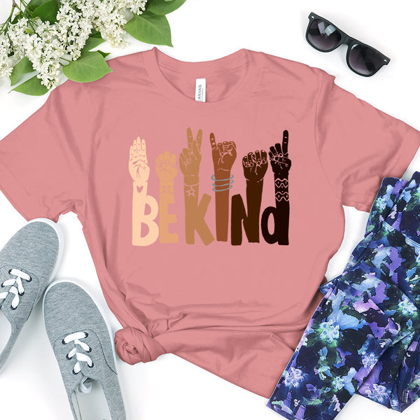 May include a graphic design featuring the phrase “BE KIND,” with each letter creatively formed by illustrated hands making various sign language gestures in different skin tones, symbolizing kindness, inclusion, and diversity.