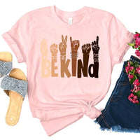 May include a graphic design featuring the phrase “BE KIND,” with each letter creatively formed by illustrated hands making various sign language gestures in different skin tones, symbolizing kindness, inclusion, and diversity.