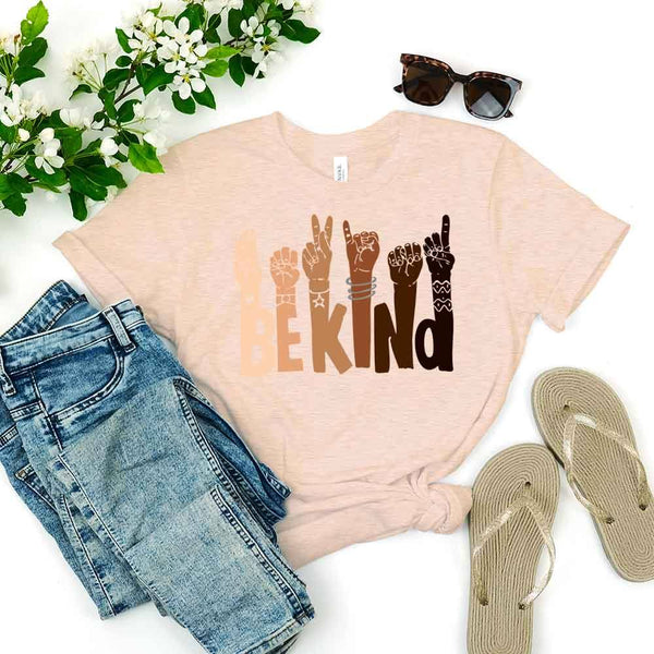 May include a graphic design featuring the phrase “BE KIND,” with each letter creatively formed by illustrated hands making various sign language gestures in different skin tones, symbolizing kindness, inclusion, and diversity.
