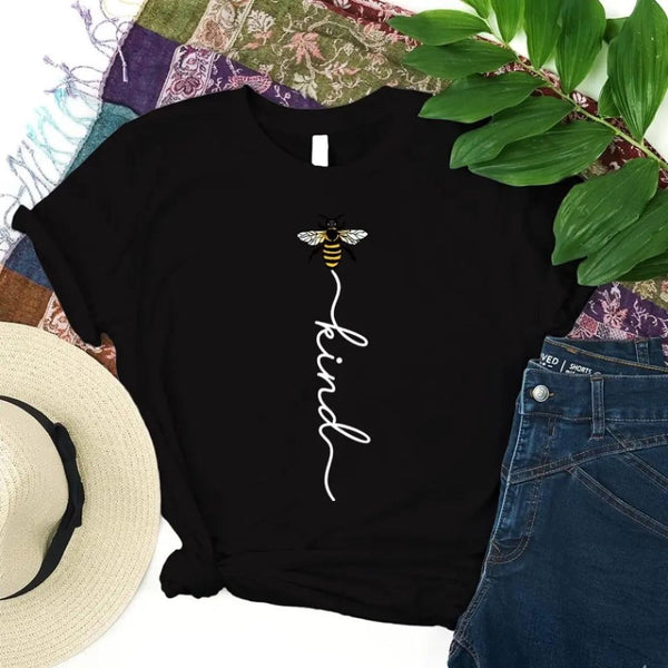 May include an inspirational t-shirt design featuring the phrase “Bee Kind” in flowing script lettering, often paired with a small bee graphic that adds a gentle, uplifting touch to the message.