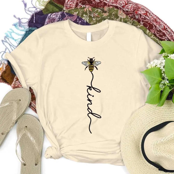 May include an inspirational t-shirt design featuring the phrase “Bee Kind” in flowing script lettering, often paired with a small bee graphic that adds a gentle, uplifting touch to the message.