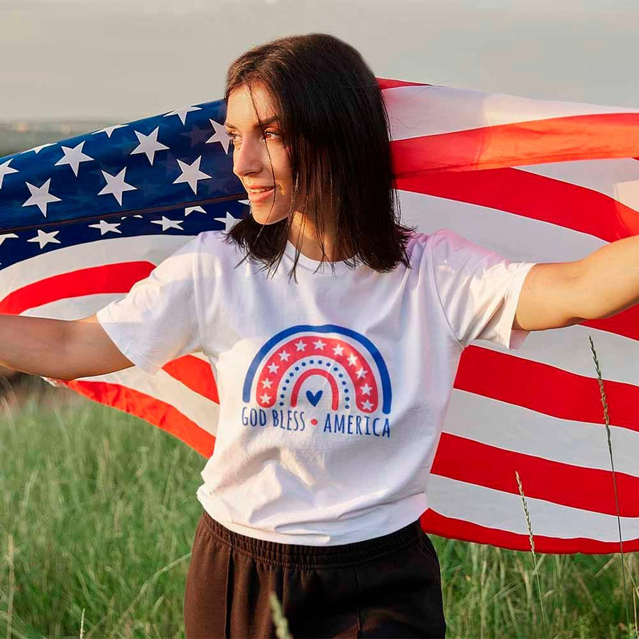 Woman holding American flag wearing patriotic shirt
