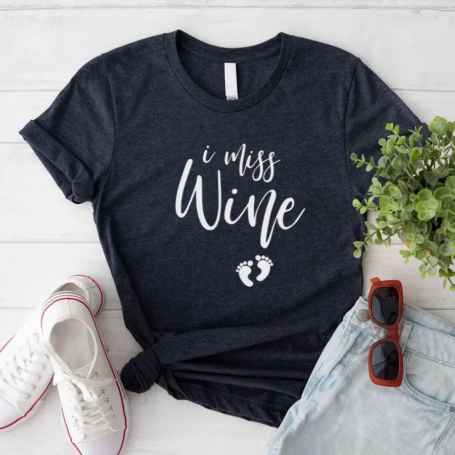 Dark grey graphic tee with 'I miss wine' and baby footprints, styled with denim shorts and sneakers