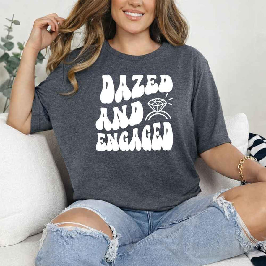 May include Dark Heather group in colorful tie-dye shirts reading “Dazed & Engaged,” smiling at a bachelorette party, with bride in veil and fun, festive vibe!
