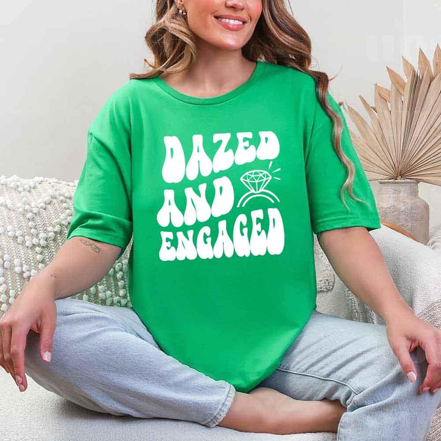 May include Green group in colorful tie-dye shirts reading “Dazed & Engaged,” smiling at a bachelorette party, with bride in veil and fun, festive vibe!