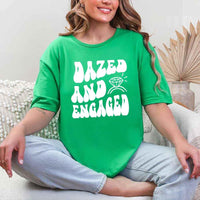 May include Green group in colorful tie-dye shirts reading “Dazed & Engaged,” smiling at a bachelorette party, with bride in veil and fun, festive vibe!