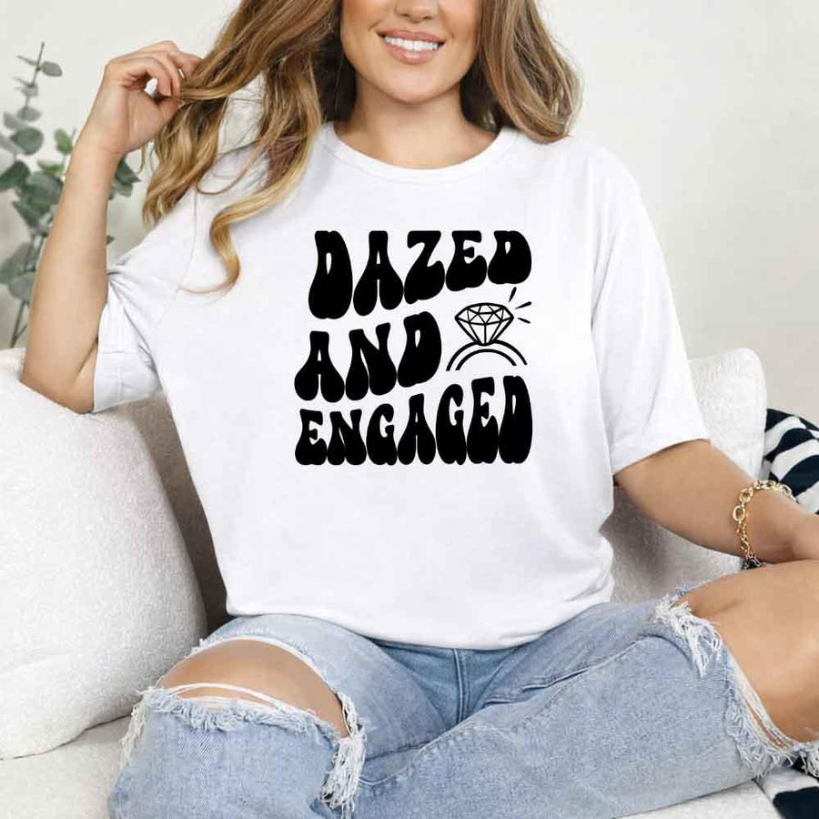 May include White group in colorful tie-dye shirts reading “Dazed & Engaged,” smiling at a bachelorette party, with bride in veil and fun, festive vibe!
