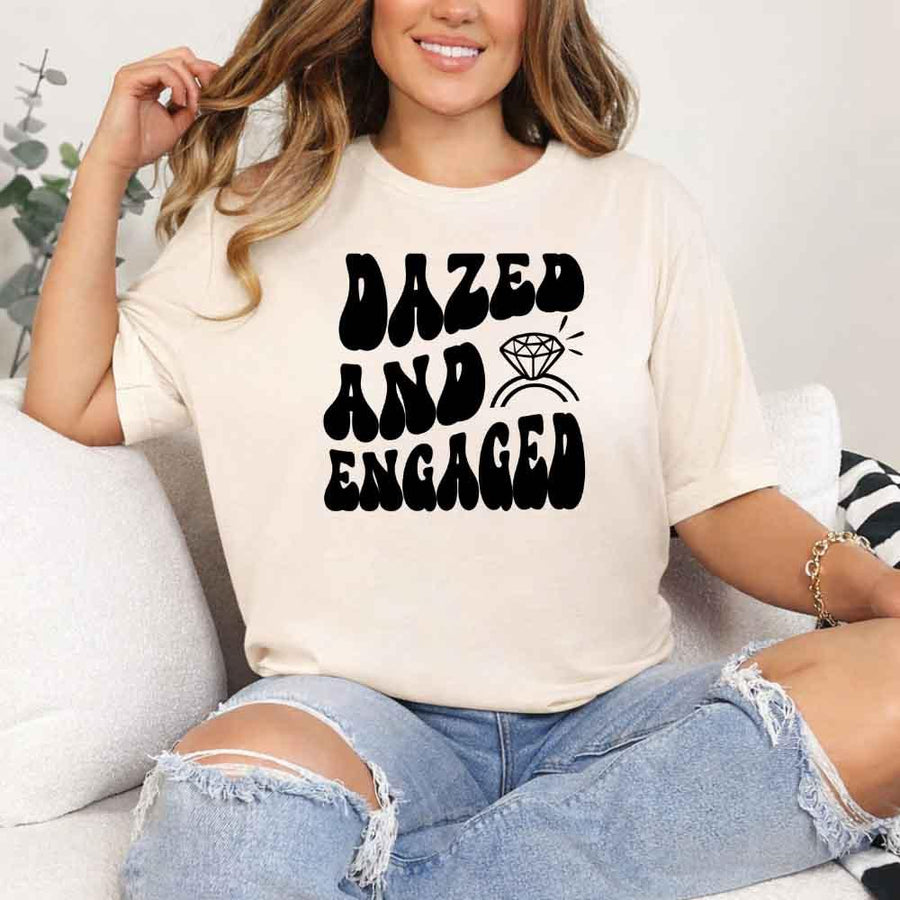 May include Cream group in colorful tie-dye shirts reading “Dazed & Engaged,” smiling at a bachelorette party, with bride in veil and fun, festive vibe!