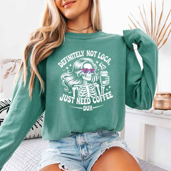 May include a women’s long sleeve shirt with the phrase “Definitely Not Loca” printed on the front in a casual, stylish design.
