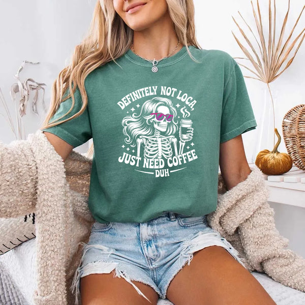 May include a short sleeve graphic tee featuring the phrase “Definitely Not Loca”  on a casual unisex shirt.