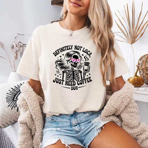 May include a short sleeve graphic tee featuring the phrase “Definitely Not Loca”  on a casual unisex shirt.