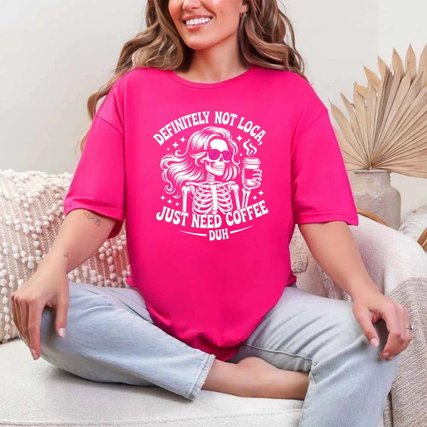 May include a short sleeve graphic tee featuring the phrase “Definitely Not Loca”  on a casual unisex shirt.