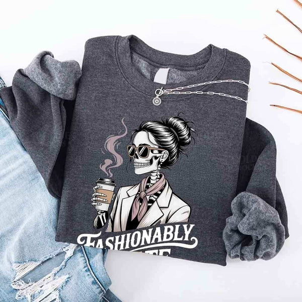 May include a long sleeve shirt featuring the phrase “Fashionably Late” in a stylish, modern font.