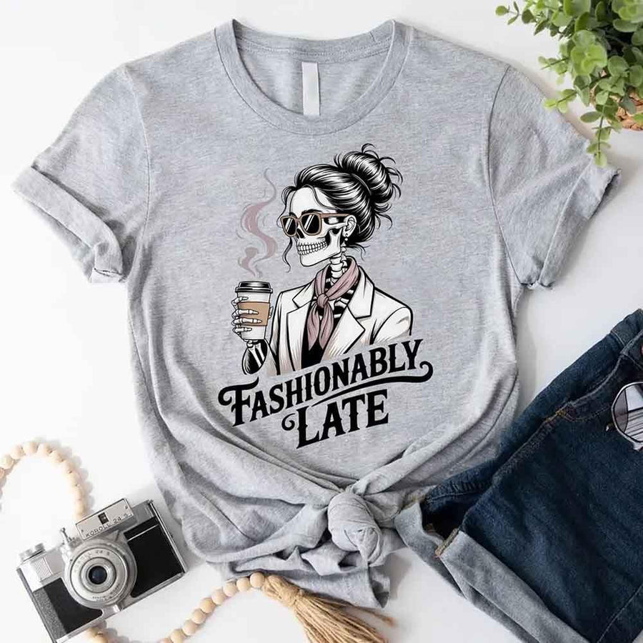 May include a short sleeve shirt featuring the phrase “Fashionably Late” in a stylish, modern font.