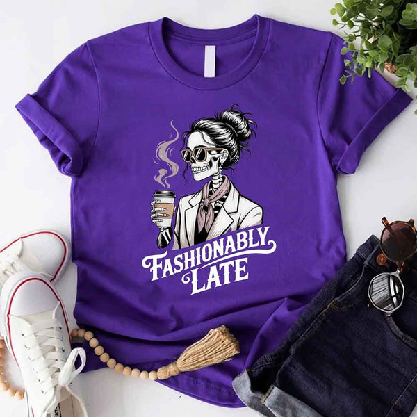 May include a short sleeve shirt featuring the phrase “Fashionably Late” in a stylish, modern font.