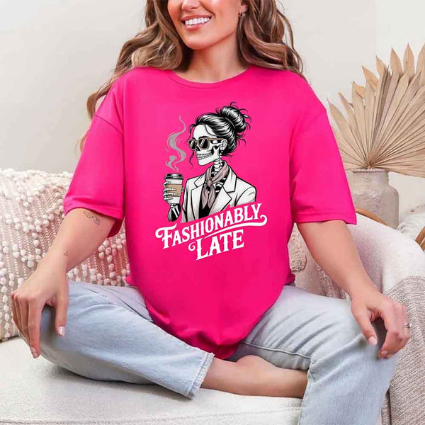 May include a short sleeve shirt featuring the phrase “Fashionably Late” in a stylish, modern font.