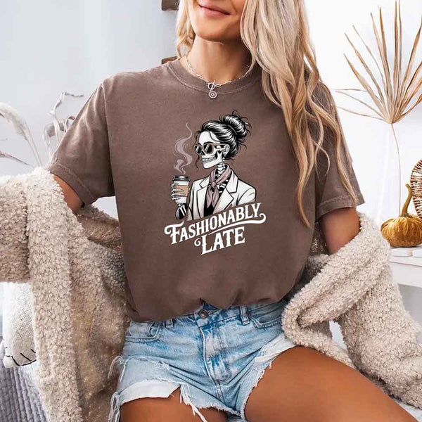 May include a short sleeve shirt featuring the phrase “Fashionably Late” in a stylish, modern font.