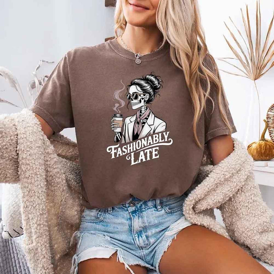 May include a short sleeve shirt featuring the phrase “Fashionably Late” in a stylish, modern font.