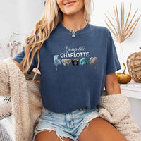 May include a person wearing a Denim Gossip Like Charlotte Wigs Comfort Colors T-Shirt featuring historical drama inspired graphic and relaxed fit.