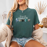 May include a person wearing a Blue Spruce Gossip Like Charlotte Wigs Comfort Colors T-Shirt featuring historical drama inspired graphic and relaxed fit.