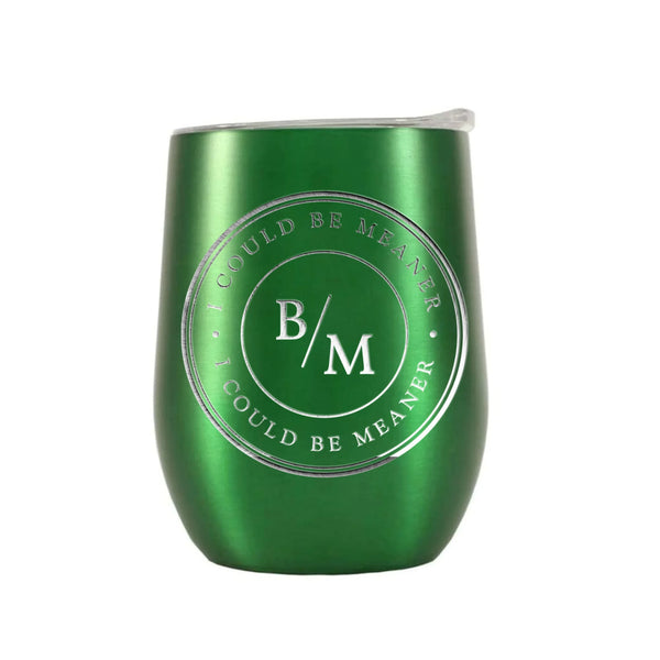 May include a wine tumbler displayed on a wooden surface, featuring a circular black design with the text “I COULD BE MEANER” repeated around the outer ring and the initials “B/M” centered inside. 