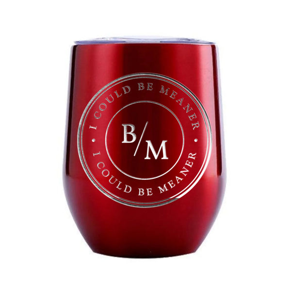 May include a wine tumbler displayed on a wooden surface, featuring a circular black design with the text “I COULD BE MEANER” repeated around the outer ring and the initials “B/M” centered inside. 