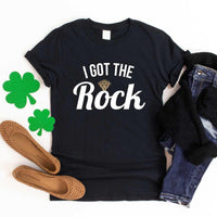 May include a couple wearing matching St. Patrick’s Day engagement t-shirts with the phrase “I Got The Rock”.