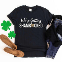 May include a couple wearing matching St. Patrick’s Day engagement t-shirts with the phrase “I Got The Rock”.
