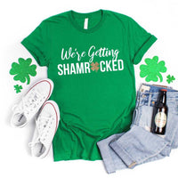 May include a couple wearing matching St. Patrick’s Day engagement t-shirts with the phrase “I Got The Rock”.