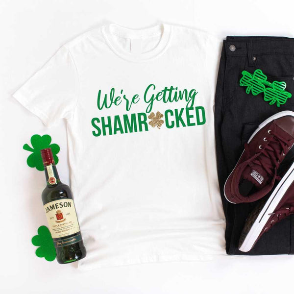 May include a couple wearing matching St. Patrick’s Day engagement t-shirts with the phrase “I Got The Rock”.