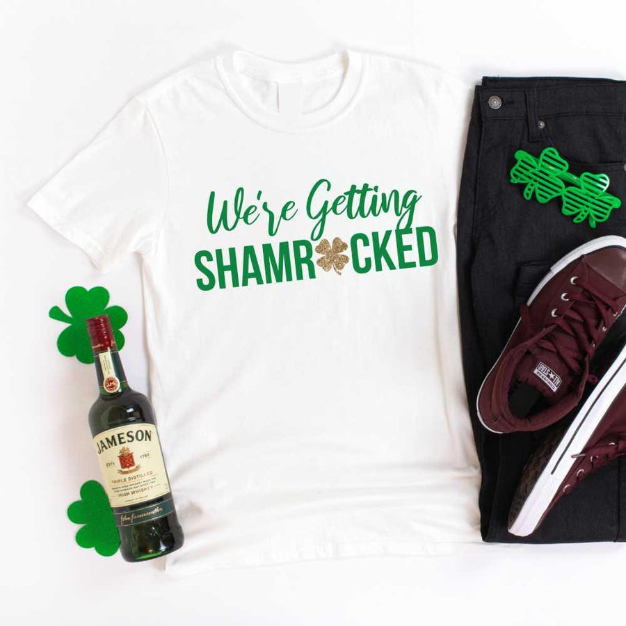 May include a couple wearing matching St. Patrick’s Day engagement t-shirts with the phrase “I Got The Rock”.