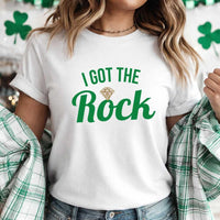May include a couple wearing matching St. Patrick’s Day engagement t-shirts with the phrase “I Got The Rock”.