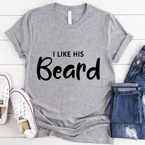 May include a pair of unisex couple t-shirts reading “I Like His Beard” and “I Like Her Butt,” displayed side by side in black and white cotton.