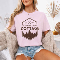 May include a person wearing a Blossom I’m Coming to the Cottage T-Shirt featuring rivalry inspired graphic design and relaxed fit.