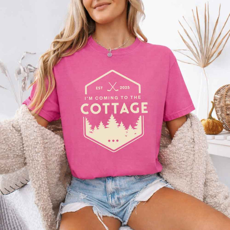 May include a person wearing a Crunchberry I’m Coming to the Cottage T-Shirt featuring rivalry inspired graphic design and relaxed fit.